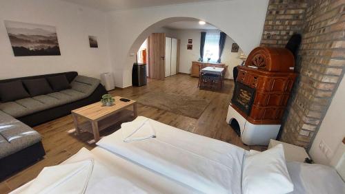 a living room with a couch and a table at Lipicai Hotel és Étterem in Szilvásvárad