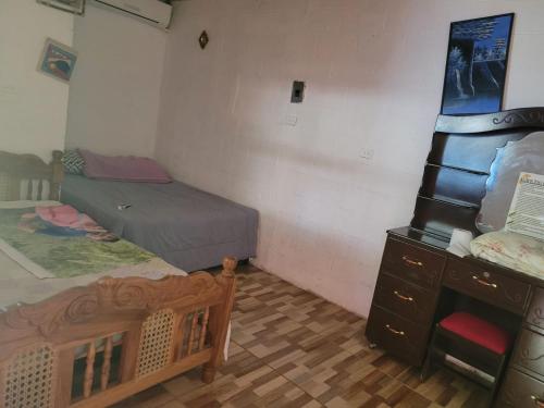 a small bedroom with two beds and a dresser at Hostal mar in Sonsonate