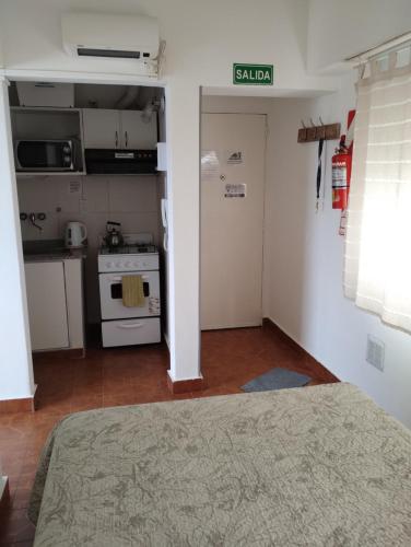 a room with a kitchen with a bed and a stove at Del Santo San Valentín in Puerto Madryn