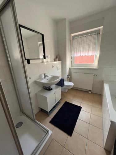 W białej łazience znajduje się umywalka i lustro. w obiekcie NP-Apartments Blasewitz w Dreźnie