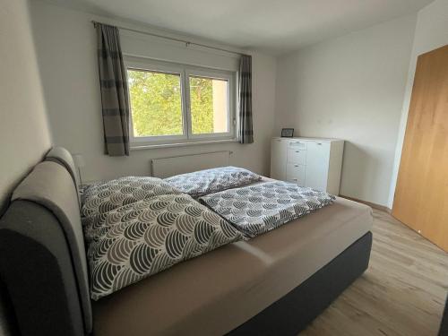 Bett in einem Schlafzimmer mit Fenster in der Unterkunft NP-Apartments Blasewitz in Dresden