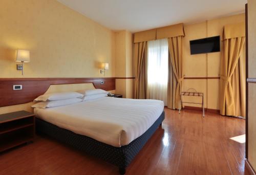 a hotel room with a large bed and a television at Best Western Hotel I Colli in Macerata