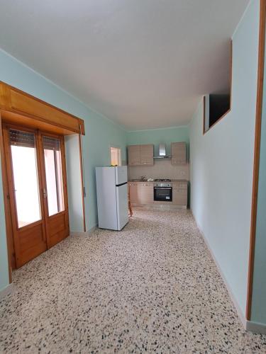 an empty kitchen with a refrigerator and a window at Casa del nonno 2 in Tursi