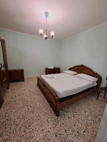 Un dormitorio con una cama grande y una lámpara de araña. en Casa del nonno 2, en Tursi