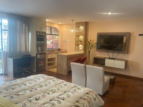Sala de estar con cama, escritorio y TV en FLAT AMOBLADO EN PUEBLO LIBRE - LIMA - PERÚ, en Lima