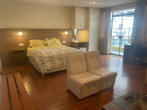 um quarto grande com uma cama e uma cadeira em FLAT AMOBLADO EN PUEBLO LIBRE - LIMA - PERÚ em Lima