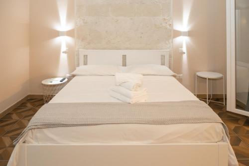 a white bed in a room with two tables at Suite.delpozzo in Capurso