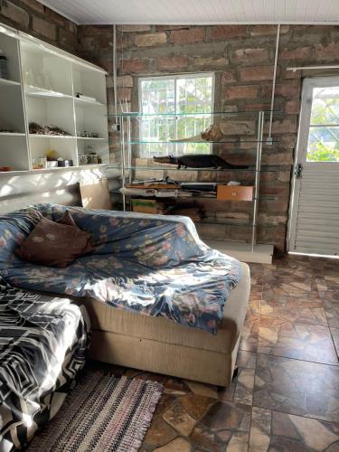 a bedroom with a bed and a brick wall at Instituto Bugio Ruivo in Eldorado do Sul 