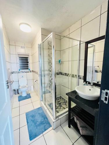 a bathroom with a shower and a sink and a toilet at Illovo Beach View in Kingsborough