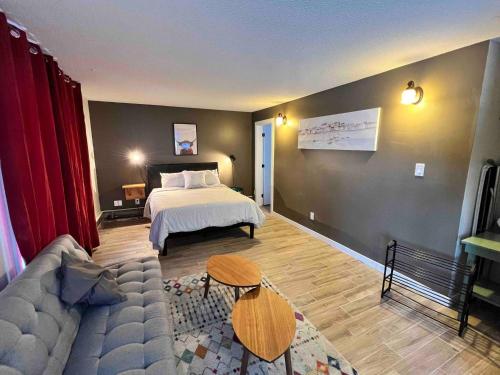 sala de estar con cama y sofá en One Bedroom Condo Near Whyte Ave Close to university, en Edmonton