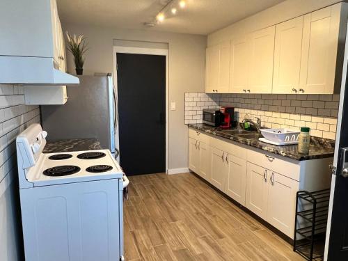 uma pequena cozinha com um fogão e um frigorífico em One Bedroom Condo Near Whyte Ave Close to university em Edmonton