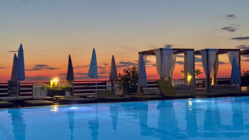 a swimming pool with chairs and umbrellas at a resort at Arabela 2 Apartments in Utjeha