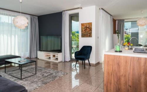 a living room with a couch and a television at Vertigo Modern 2-Bedroom Apartment with Parking & Vitosha View in Sofia