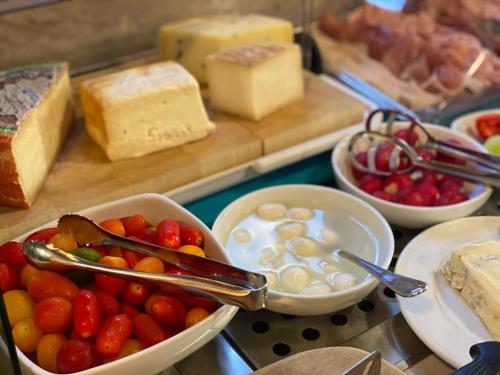 a table topped with bowls of cheese and other foods at Hotel Grifone in Sirmione