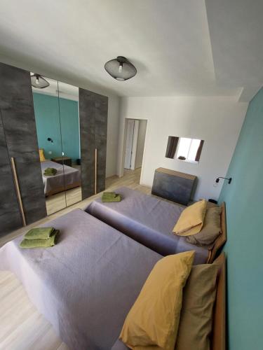 a bedroom with two beds and a large mirror at Serenity Apartment in Marsalforn