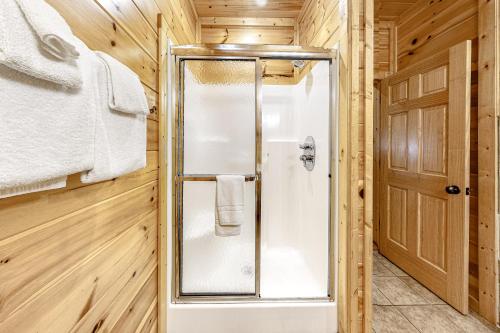 baño con ducha en una cabaña de madera en Mountain Rendezvous, en Gatlinburg