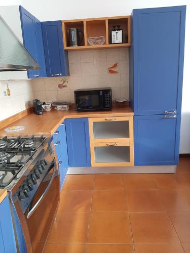 a kitchen with blue cabinets and a stove top oven at Appartamento Imola con splendida vista sul Duomo in Imola