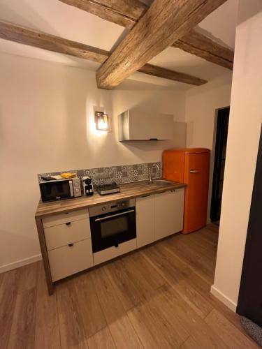 a small kitchen with a stove and a refrigerator at La Vitrine in Gertwiller