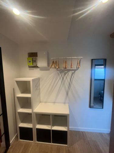 a room with a white shelf and a mirror at La Vitrine in Gertwiller