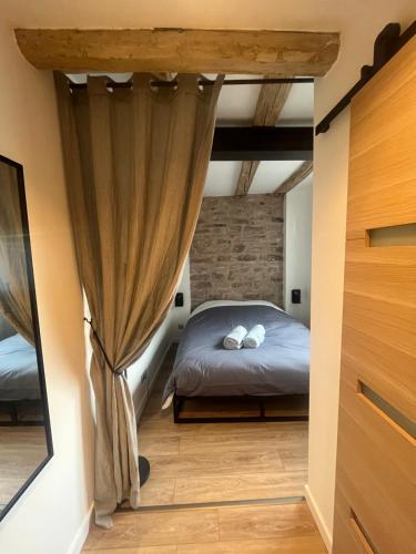 ein Schlafzimmer mit einem Bett und Vorhängen in einem Zimmer in der Unterkunft La Vitrine in Gertwiller