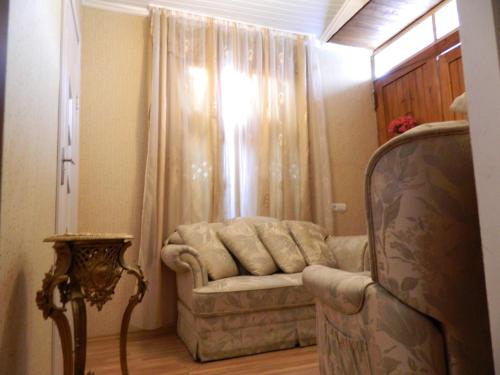 a living room with a chair and a window at Guest house Gidi in Sighnaghi