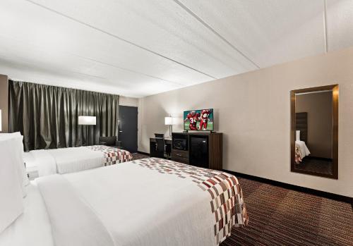 um quarto de hotel com duas camas e um espelho em Red Roof Inn Reading em Reading