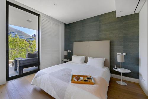 a bedroom with a large bed and a balcony at Marina 107 in Cape Town