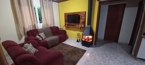 ein Wohnzimmer mit einem Sofa und einem Kamin in der Unterkunft Casa da Roça in Gonçalves