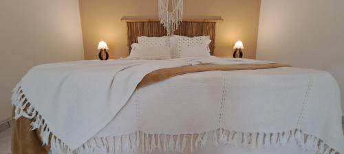 een groot wit bed met witte dekens en kussens bij Estância Villa Ventura in Socorro
