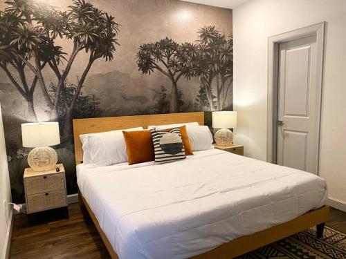 a bedroom with a large white bed with two lamps at Urban Jungle Retreat in the HTX Skyline in Houston