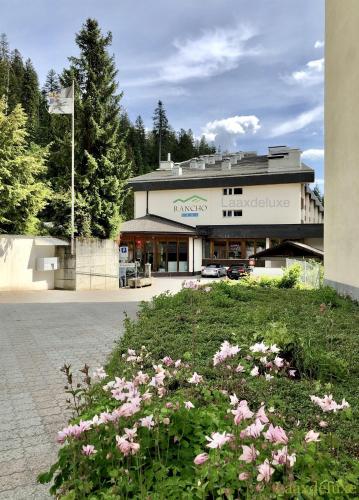 a building with a lot of flowers in front of it at Rancho Laaxdeluxe in Laax