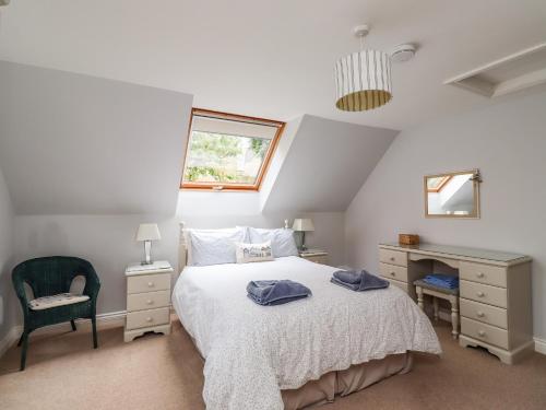 a bedroom with a bed and a desk and a window at Quarry Haven in Bamburgh