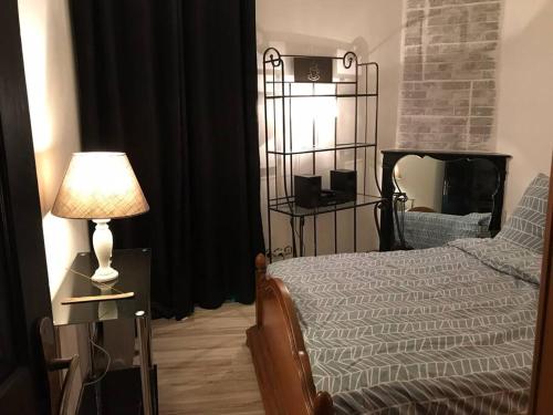 een slaapkamer met een bed, een lamp en een spiegel bij Appart Mama - Visiter Paris et Disneyland en famille à petit prix in Romilly-sur-Seine