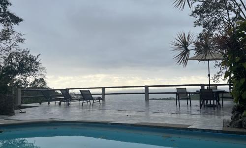 a patio with a table and chairs next to a swimming pool at Samai Lodge Holistic Living in Olón