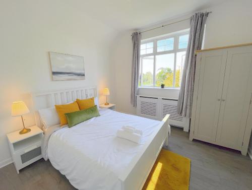 Un dormitorio con una gran cama blanca y una ventana en The Opulent House Kent, en Sheerness