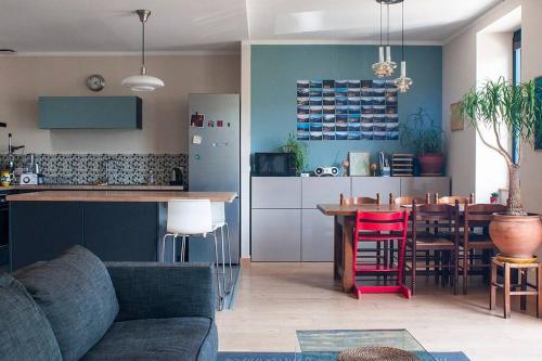 eine Küche und ein Wohnzimmer mit einem Sofa und einem Tisch in der Unterkunft Le balcon du boulevard bellevue in Saint-Claude