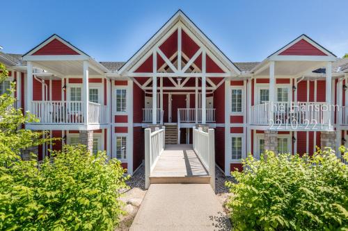 a large red and white building with a porch at Country Club Charm - 4-Bed Radiant Resort Condo in Edgar