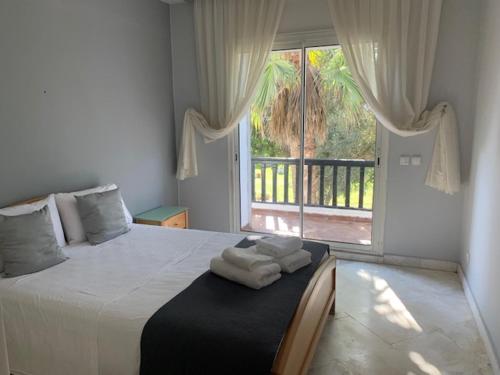 een slaapkamer met een bed met twee handdoeken erop bij Bord de mer, villa de luxe in Casablanca