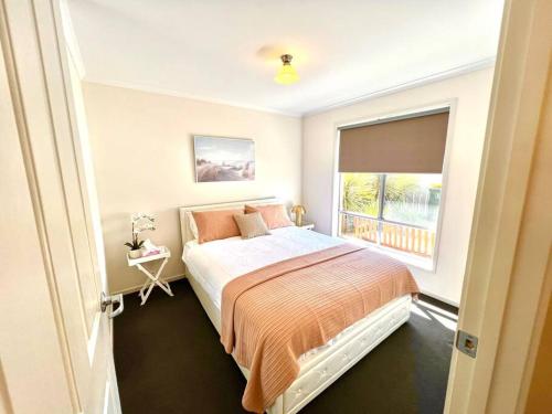 a bedroom with a large bed with a window at Seaside Sanctuary Port Noarlunga in Port Noarlunga South