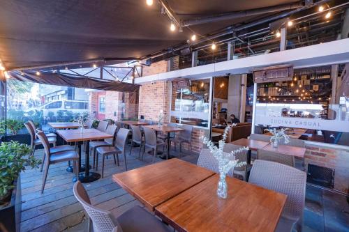 a restaurant with wooden tables and chairs in a room at Hotel B3 Virrey in Bogotá