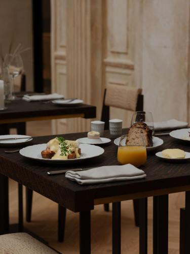 a table with plates of food and a glass of orange juice at Grand Hotel in Łódź