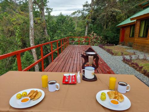 uma mesa com dois pratos de ovos e pão em Cabañas Don Tito em Pejibaye