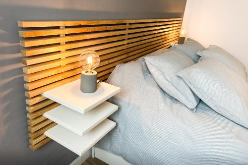 1 dormitorio con 1 cama con cabecero de madera en Piso moderno a 15 minutos andando del centro en Huelva