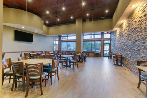 a dining room with tables and chairs and windows at Best Western Plus Westbank in Harvey