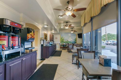 un restaurante con un bar con mesas y sillas en Best Western Plus Westbank, en Harvey