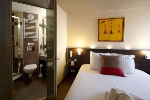 ein Hotelzimmer mit einem Bett und einem Bad in der Unterkunft Best Western l'Atelier 117 in Maubeuge
