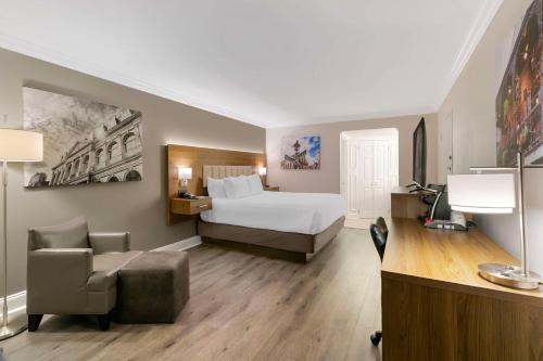 a hotel room with a bed and a chair at Best Western Plus Westbank in Harvey
