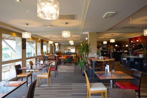 a dining room with tables and chairs and a restaurant at Best Western l'Atelier 117 in Maubeuge