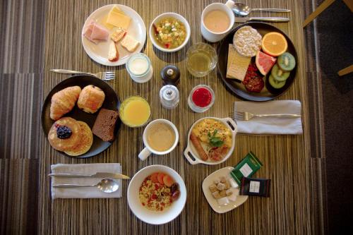 a table with plates of breakfast foods and drinks at Best Western l'Atelier 117 in Maubeuge