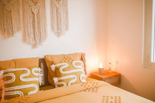 une chambre avec un lit avec deux oreillers dessus dans l'établissement Maison Bobochic parking et jardin by Art de Voyager, à Étretat